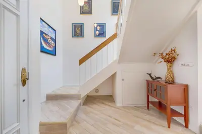 a hallway with stairs and a vase on a table at Tattenham 1705 in Encinitas