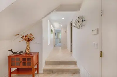 a hallway with white walls and a vase on a table at Tattenham 1705 in Encinitas