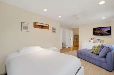 a bedroom with a white bed and a couch at Tattenham 1705 in Encinitas