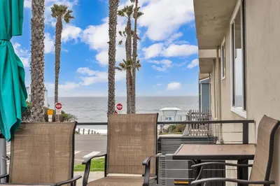 a patio with tables and chairs and a view of the ocean at Tower 9 #1 in Oceanside