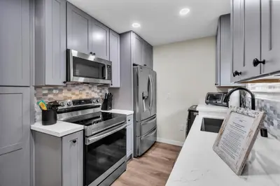 a kitchen with gray cabinets and stainless steel appliances at Tower 9 #4 in Oceanside