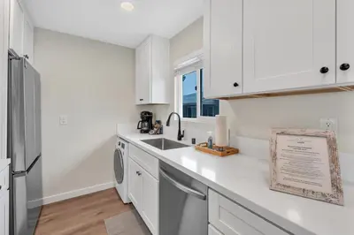a white kitchen with a sink and a dishwasher at Tower 9 #5 in Oceanside