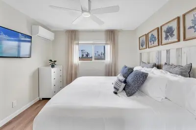 a white bedroom with a large white bed with pillows at Tower 9 #5 in Oceanside