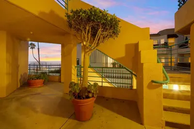 a balcony with potted plants on a yellow building at San Miguel #8 in Oceanside