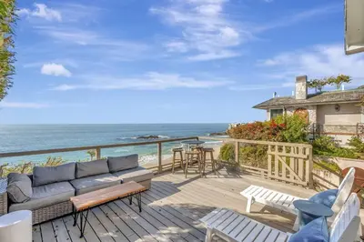 a patio with a couch and a view of the ocean at OCEAN FRONT Beach HOUSE! Private Stairs to SAND! in Laguna Beach