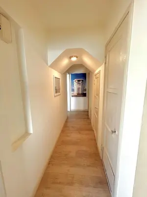 a hallway with white walls and a wooden floor at OCEAN FRONT Beach HOUSE! Private Stairs to SAND! in Laguna Beach