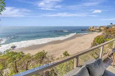 a view of the beach from the balcony of a house at OCEAN FRONT Beach HOUSE! Private Stairs to SAND! in Laguna Beach