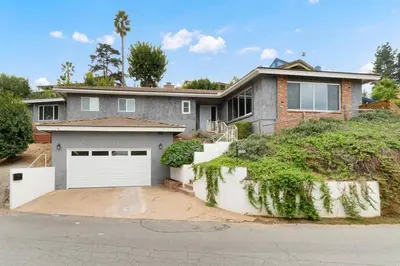 a brick house with a white garage door at Designer 4 BR La Mesa Home w/ Yard and BBQ in La Mesa