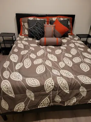 a bed with a brown and white comforter and pillows at Hotel Gigi in San Diego
