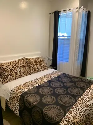 a bedroom with a leopard print bed and a window at Hotel Gigi in San Diego
