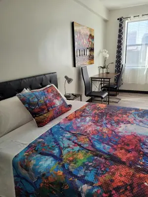 a bedroom with a bed with a colorful blanket on it at Hotel Gigi in San Diego