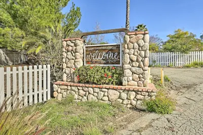 a stone wall with a sign in front of a fence at Garden, Gazebo and Fire Pit Fallbrook Home! in Fallbrook