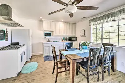 a kitchen with a table with chairs and a ceiling fan at Garden, Gazebo and Fire Pit Fallbrook Home! in Fallbrook