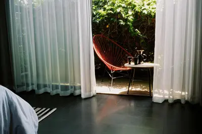 a room with a window with a chair and a table at Twelve Senses Retreat in Encinitas