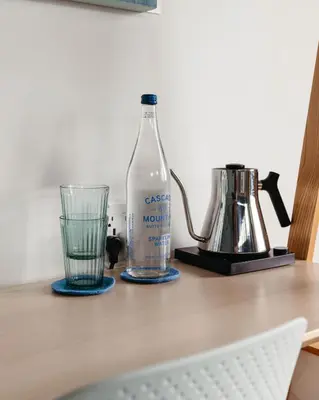 a bottle of water and a glass on a table at Twelve Senses Retreat in Encinitas