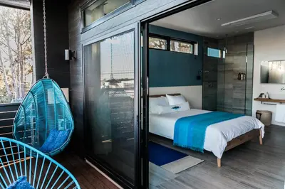a bedroom with a swinging bed and a glass window at Twelve Senses Retreat in Encinitas