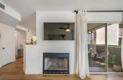 a living room with a fireplace and a window at Ritz Pointe Paradise! in Dana Point