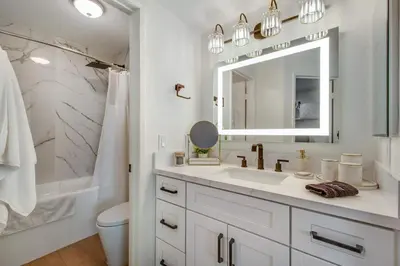 a white bathroom with a sink and a mirror at Ritz Pointe Paradise! in Dana Point