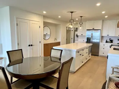 a kitchen with a glass table and chairs in it at Oceanfront Fully Remodeled 2BR 2BA, Pool, Hot Tub, Gated Parking in Solana Beach