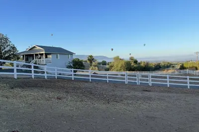a white fence in front of a white house at Chick-Ranch Guest House in Temecula