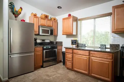 a kitchen with wooden cabinets and a stainless steel refrigerator at Chick-Ranch Guest House in Temecula