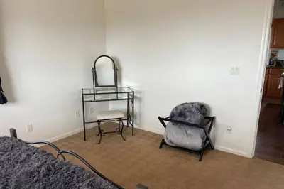 a bedroom with a chair and a table and a mirror at Chick-Ranch Guest House in Temecula