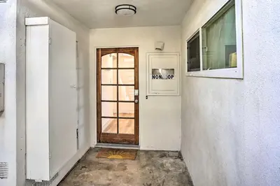 an empty hallway with a door and a window at San Clemente Condo with Gorgeous Views Near Beach! in San Clemente