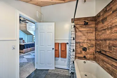 a bathroom with a tub and a wooden wall at Inviting Julian Home with Scenic View and Hot Tub in Julian