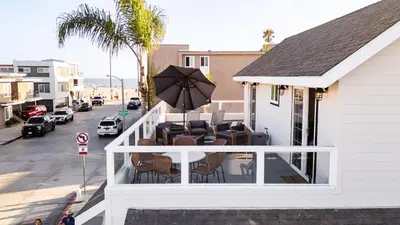 a balcony with chairs and an umbrella on a building at Sea Sight by AvantStay Walk to Newport Beach in Newport Beach