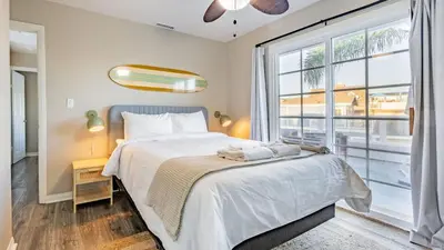 a bedroom with a bed and a large window at Sea Sight by AvantStay Walk to Newport Beach in Newport Beach
