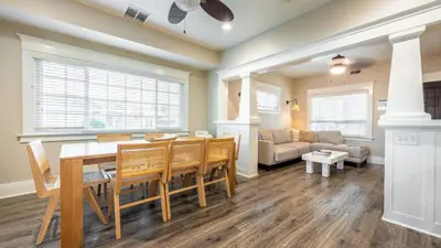 a dining room and living room with a table and chairs at Sea Sight by AvantStay Walk to Newport Beach in Newport Beach