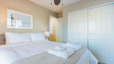 a bedroom with a white bed with towels on it at Sea Sight by AvantStay Walk to Newport Beach in Newport Beach