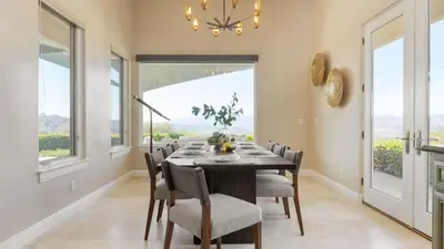 a dining room with a table and chairs and windows at Modern Temecula Mansion w Pool Hot Tub Guest House Valley Views Camila by AvantStay in Temecula