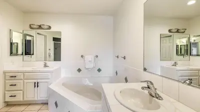 a white bathroom with two sinks and a tub at 5-Acre Hilltop Estate w Resort Pool Game Room Le Grand Bleu by AvantStay in Temecula