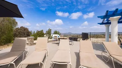 a row of chairs and a table on a patio at 5-Acre Hilltop Estate w Resort Pool Game Room Le Grand Bleu by AvantStay in Temecula