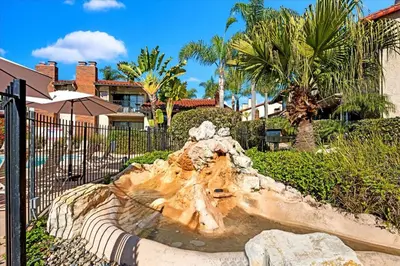 a fountain in a park in front of a fence at Carlsbad Hideway Pool Spa in Carlsbad