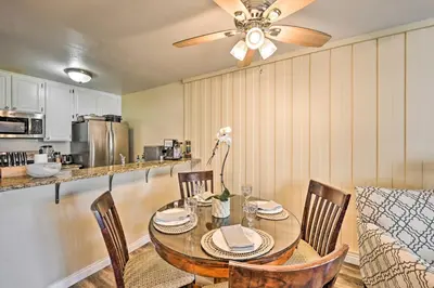 a dining room table with chairs and a ceiling fan at Deja Blue Oceanside Condo on Beach with Pools! in Oceanside