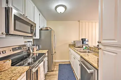 a kitchen with a stainless steel refrigerator and a sink at Deja Blue Oceanside Condo on Beach with Pools! in Oceanside