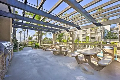 a pergola with benches and tables on a patio at Deja Blue Oceanside Condo on Beach with Pools! in Oceanside