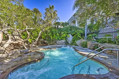 a hot tub in a garden with a tree at Deja Blue Oceanside Condo on Beach with Pools! in Oceanside