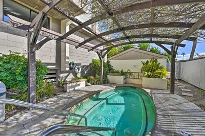 a hot tub in a backyard with a pergola at Deja Blue Oceanside Condo on Beach with Pools! in Oceanside