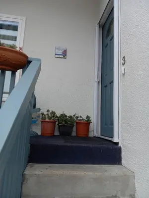 a blue door with potted plants on the steps at Master SUITE STEPS TO BAY & BEACH in San Diego