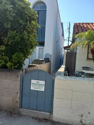 a blue gate with a sign on it in front of a building at Master SUITE STEPS TO BAY & BEACH in San Diego