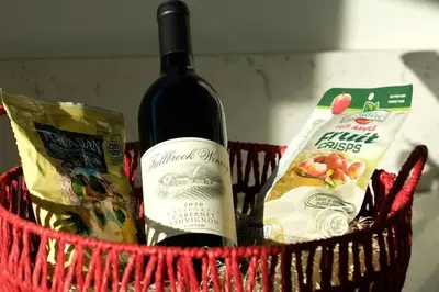 a red basket with a bottle of wine and snacks at Aviation Landing in Fallbrook