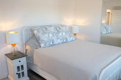 a white bed with two lamps on a side table at Aviation Landing in Fallbrook