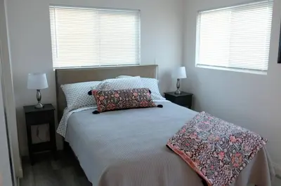 a bedroom with a bed with two pillows and two windows at Aviation Landing in Fallbrook