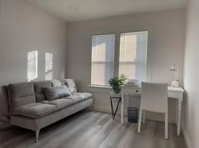a living room with a couch and a table and windows at Aviation Landing in Fallbrook