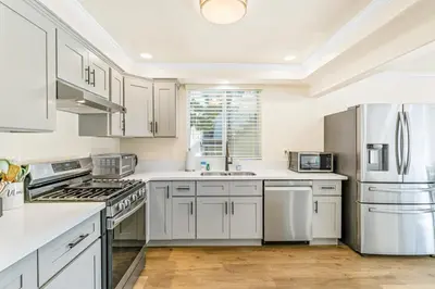 a kitchen with white cabinets and stainless steel appliances at 4912 Seashore A Lower in Newport Beach