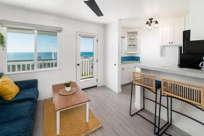 a living room with a blue couch and a kitchen at Pacific Villas in Oceanside