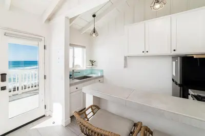 a kitchen with white cabinets and a view of the ocean at Pacific Villas in Oceanside